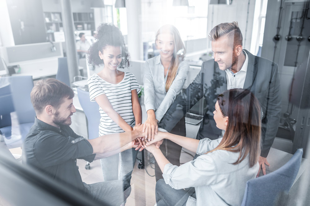 En man håller laptop i ena handen och en leende kvinna scrollar igenom deras dokument